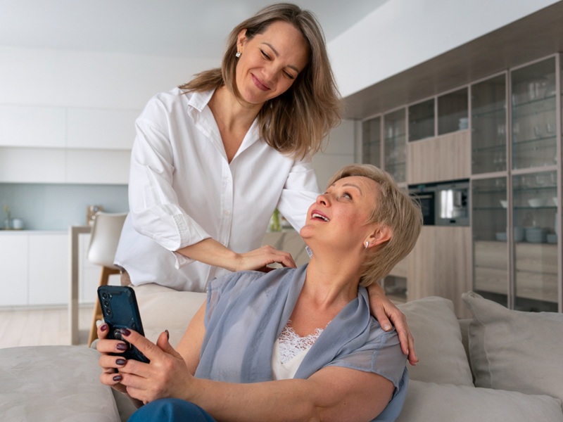 Dignity in Personal Care: Respectful Help for Seniors Daughter resting a hand on her mother’s shoulder at home, offering dignity in personal care